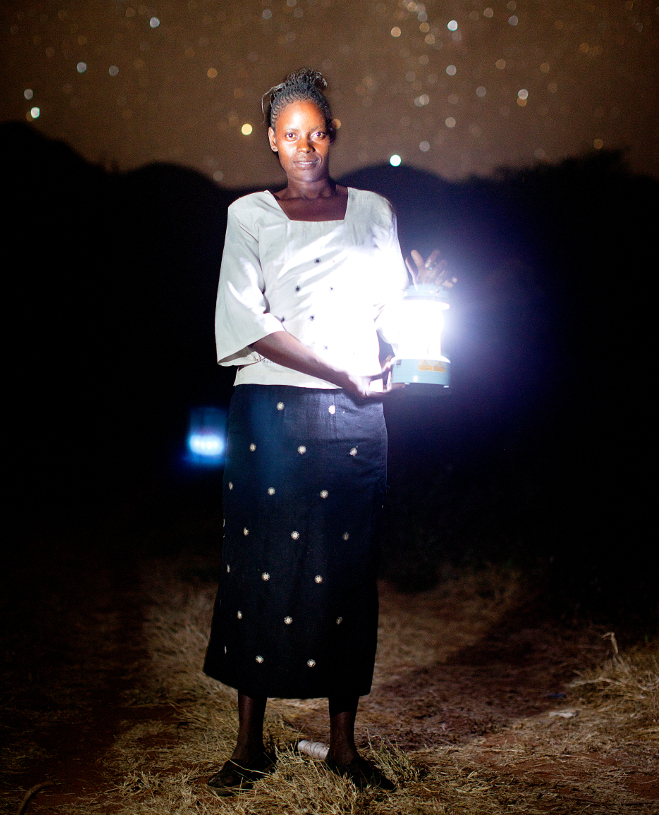 Woman in Ikisaya village in Kenya using a portable solar lantern