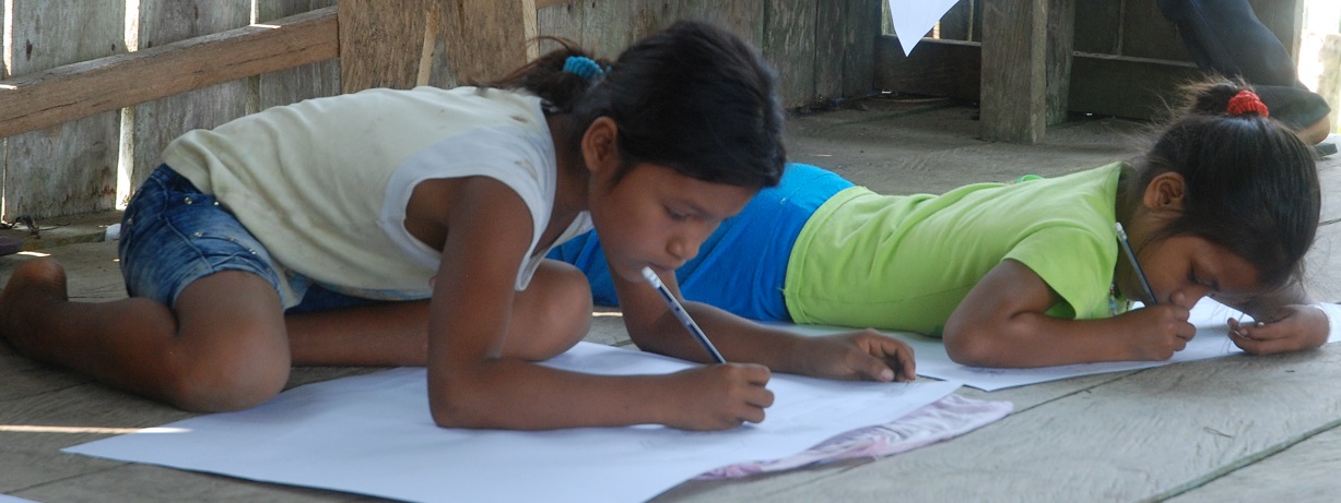 Barn som sitter på gulvet og tegner illustrasjoner. 