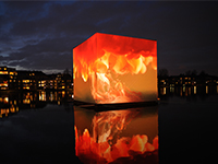 Media Cube-installasjon for COP15 klimakonferanse i København, desember 2009. Kuben står tilsynelatende på vann og viser oransje flammer på alle kanter.