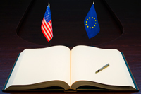 An open book and the american flag and flag for the european union.