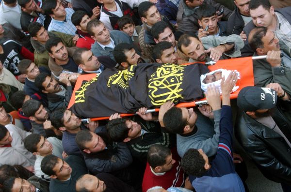 Group of people carrying the body in a burial march.