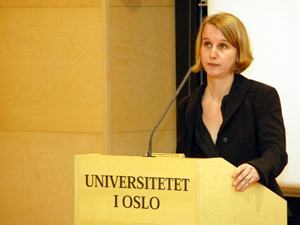 A woman (Cathrine Holst) giving a speech at a podium at the University of Oslo.