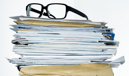 pile of documents with glasses on top