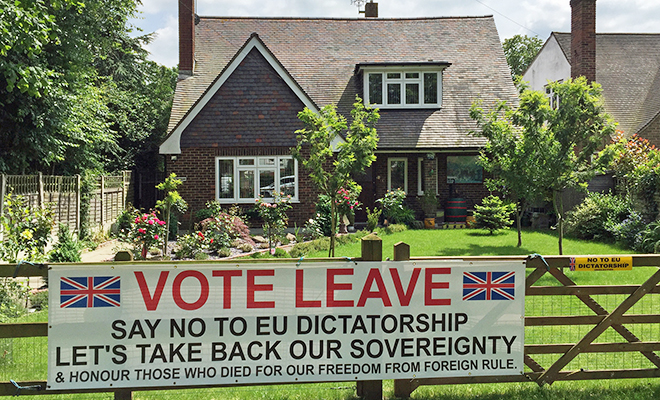 A british house with a sign on the front fence. Text on the banner: "Vote leave. Say no to EU dictatorship. "Let's take back our sovereignity & honour those who died for our freedom from foreign rule".