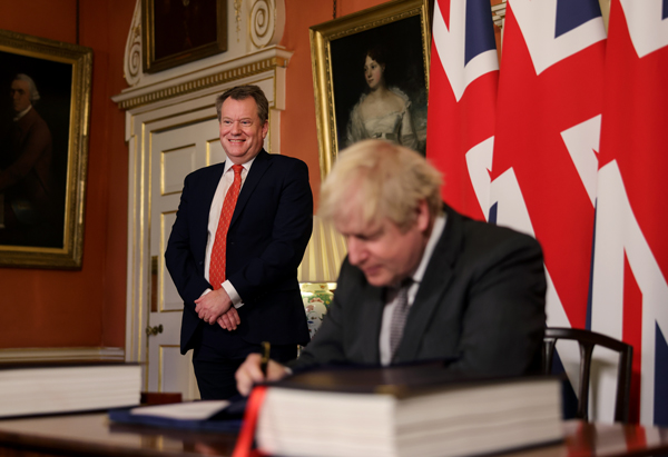 Boris Johnson og en mann i bakgrunnen.