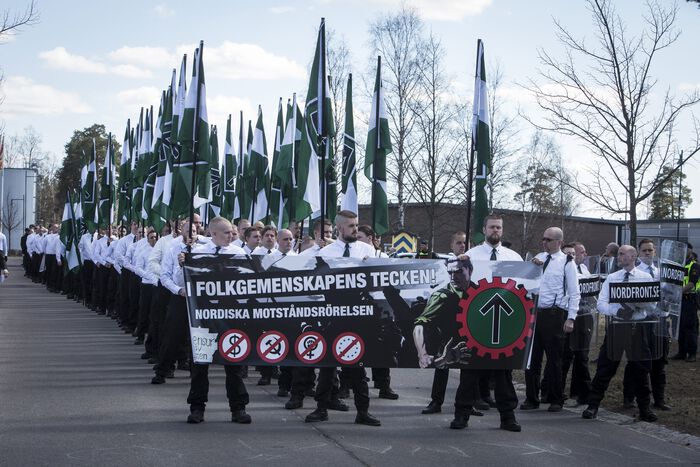 Men in white shirts and with green flags
