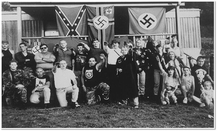 black and white group photo with nazi flags and people doing the sieg heil