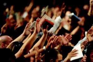 large audience holding their hands up