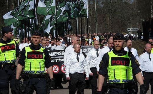 men in white shirts in a demonstration, surrounded by police