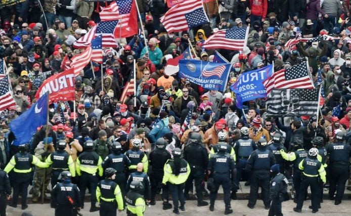 large group of people and police during the storming of the US capitol