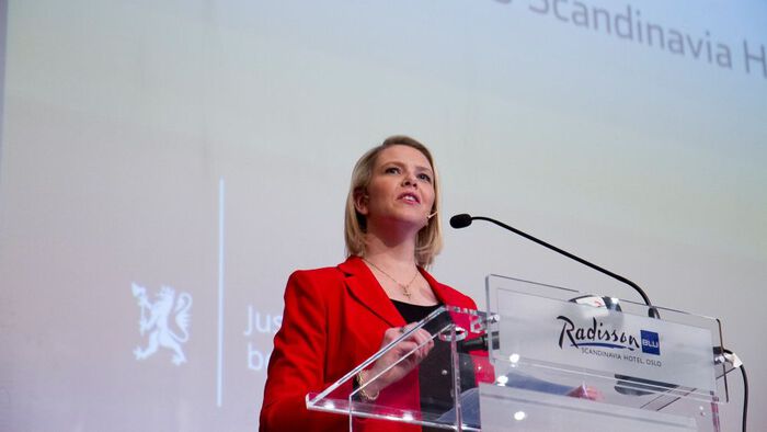 woman in a red jacket speaking