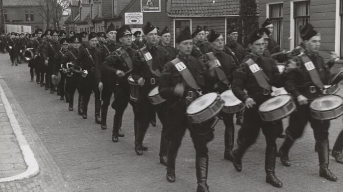 black and white image of a marching parade with drums