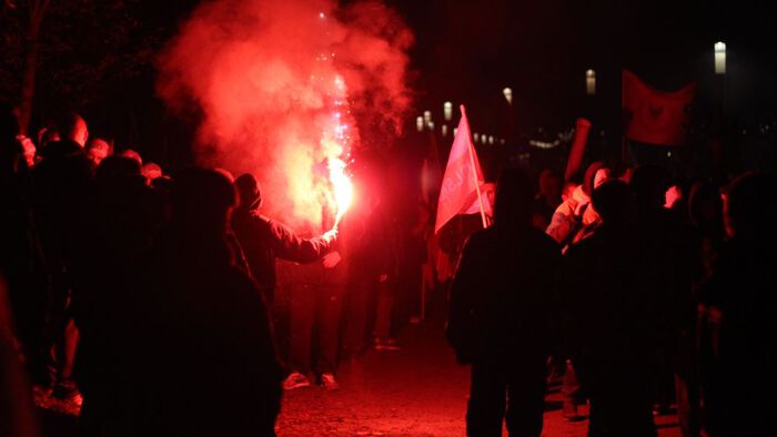 crowd and a red flame, night time