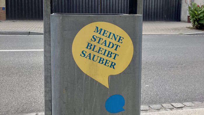 sign on a trash can with the text "meine stadt bleibt sauber"