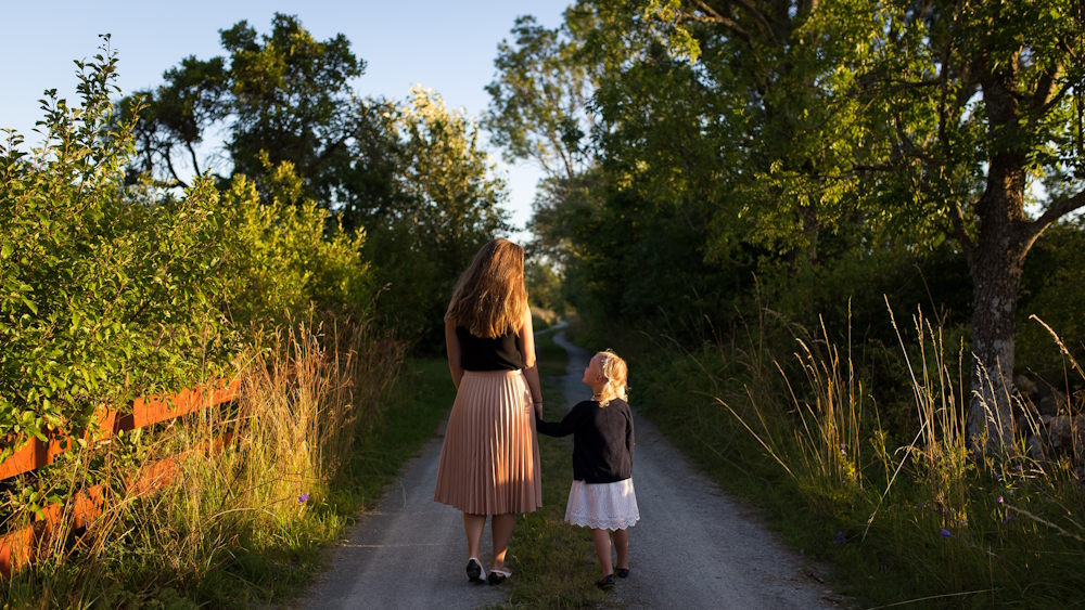 woman and child walking on a nature path