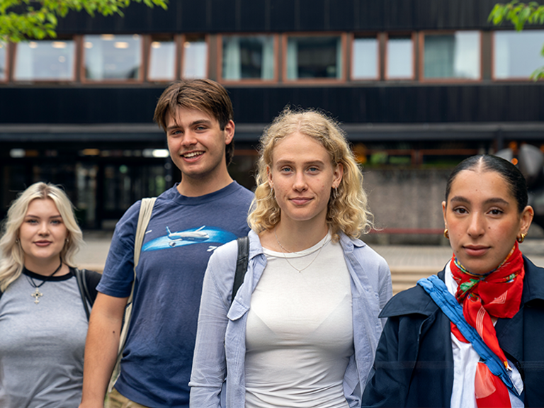 4 studenter som står foran SV-bygningen