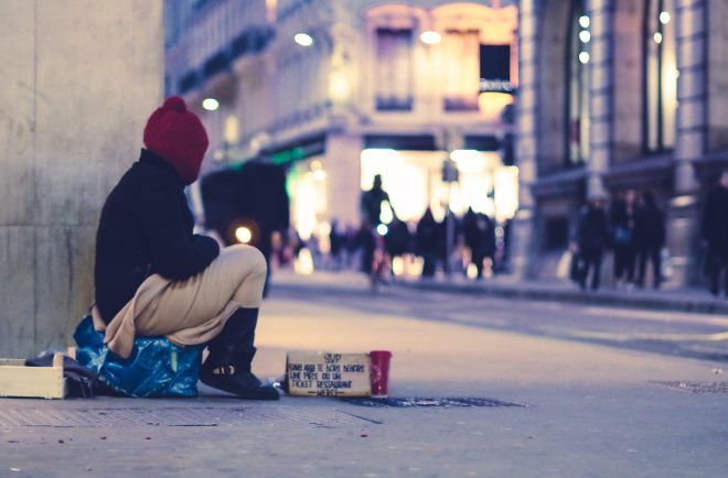 Hjemløs person som sitter på gata