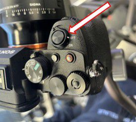 Close-up of the camera power switch, with an arrow pointing to the switch set to OFF