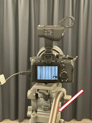 Camera on the tripod, with an arrow pointing to the handle