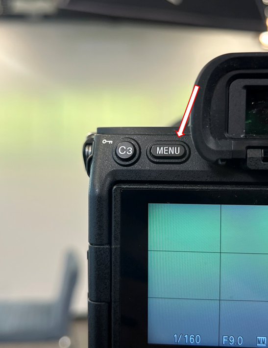 Camera with an arrow pointing to the MENU button