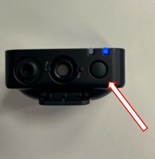 Arrow pointing to the button on the underside of the microphone