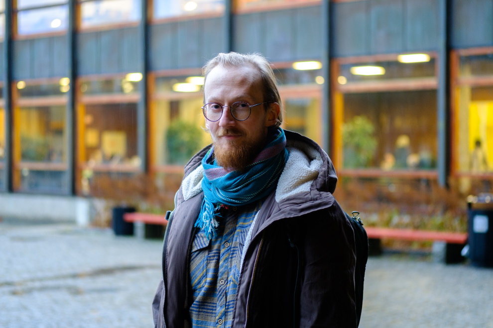 ung mann med briller og skjegg står foran Eilert Sundts hus