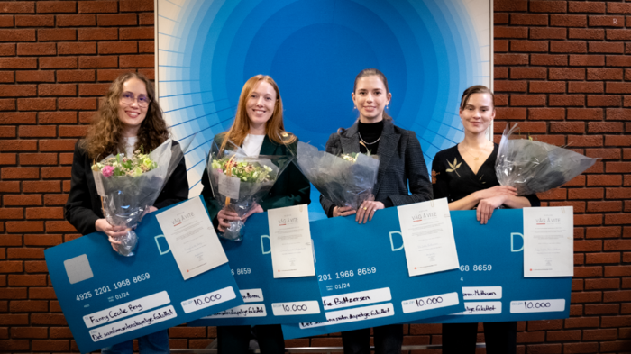 4 prisvinnere poserer med blomster og pengesjekk