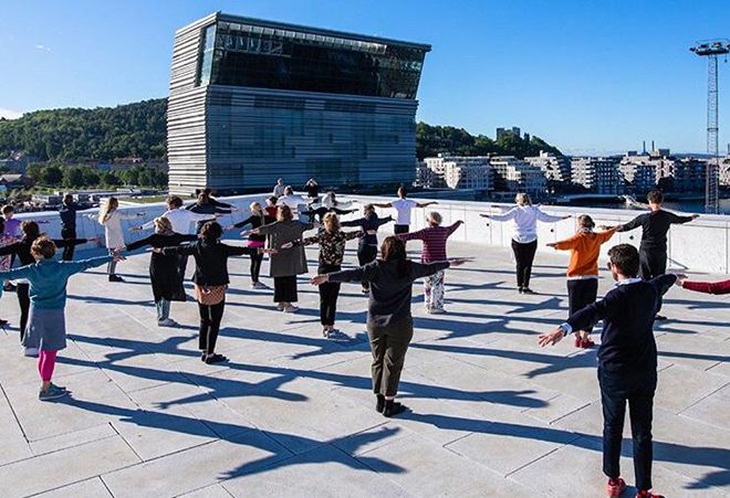 People doing excercises on the roof top of the Oslo Opera House