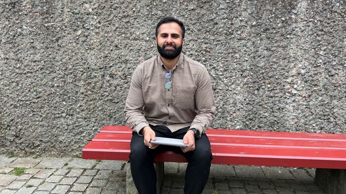 Man with beard sitting on  red bench