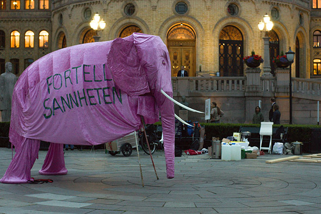 Demonstrasjon utenfor Storinget med en stor lilla elefanf med teksten "Fortell sannheten"