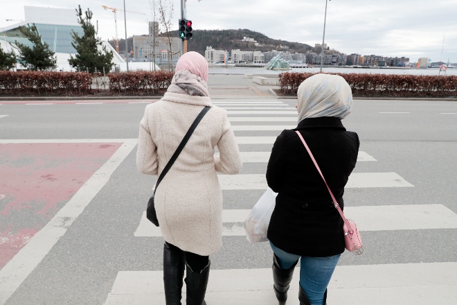 To kvinner med hijab, sett bakfra, på gata.