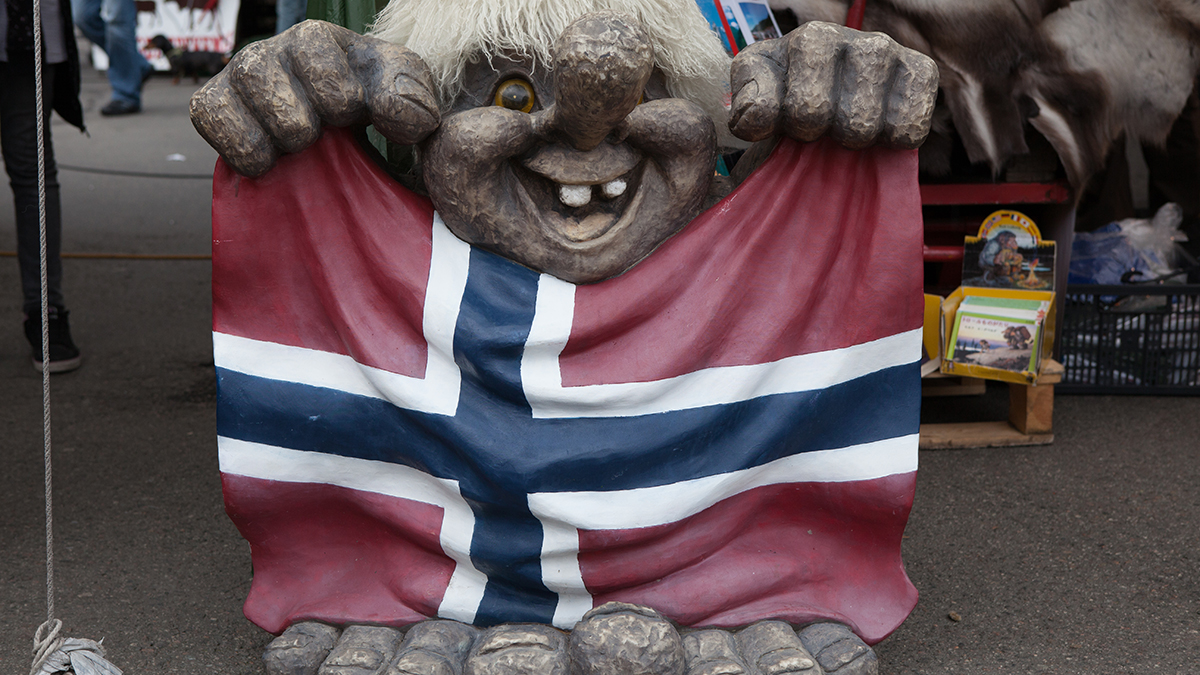 Troll som holder norsk flagg.