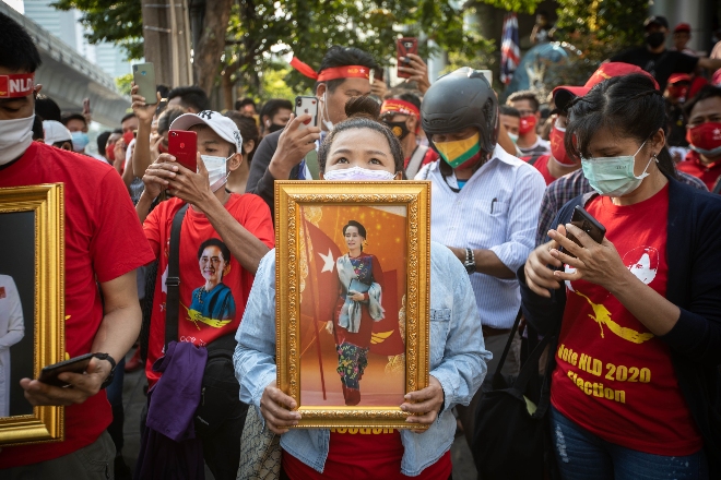 En kvinne i en demostrasjon holder et bilde av Aung San Suu Kyi