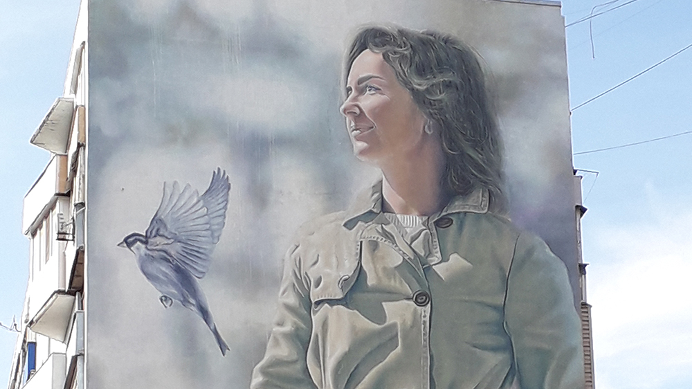 Veggmaleri av kvinne og flyvende due