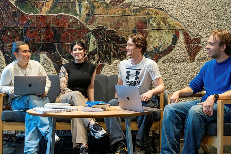 Students sitting around a table talking.