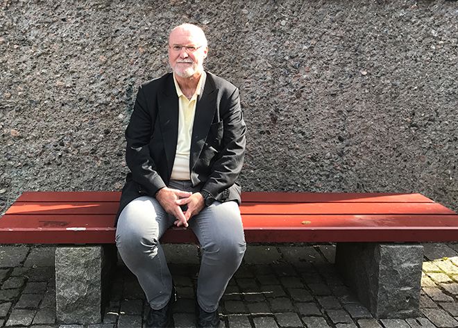 Bernt Aardal som sitter en benk