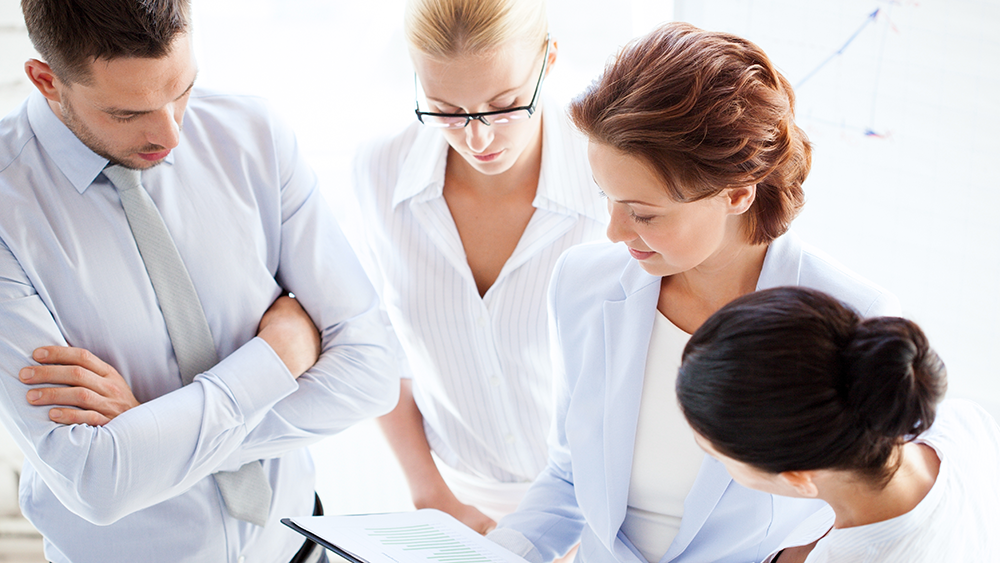 Four people discusses a document