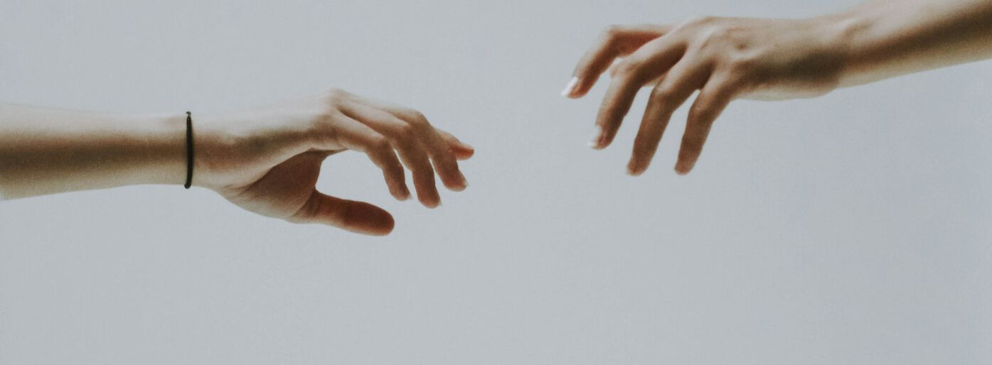 Two hands reaching towards each other