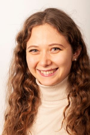 Portrett av smilende kvinne med langt mørkt bølgende hår