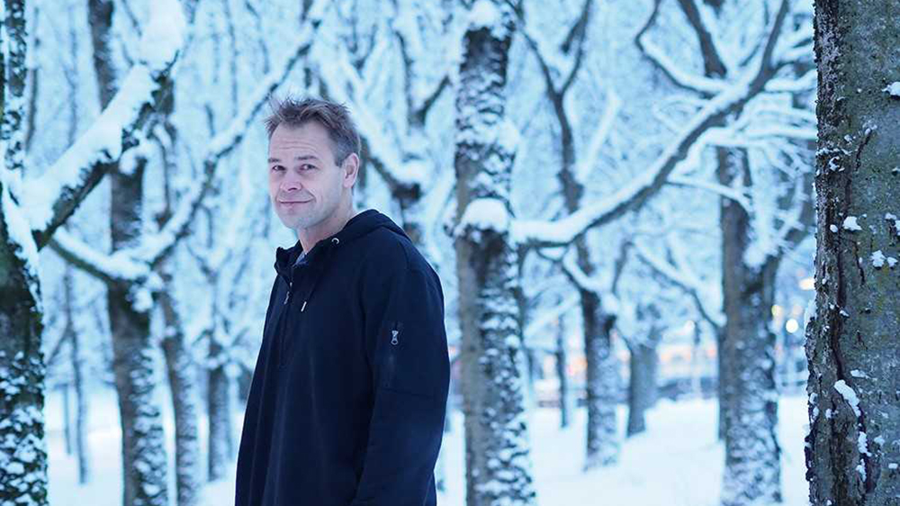 Portrett av Bård Harstad foran snødekte trær