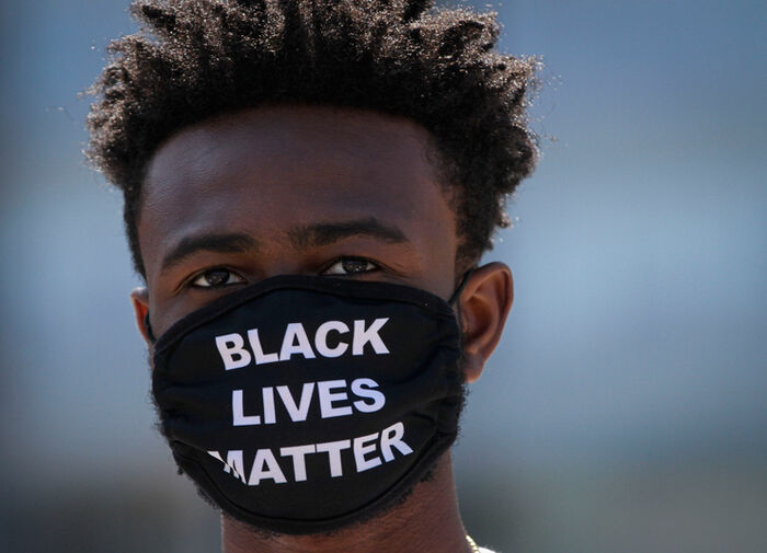 Person med munnbind med teksten "black lives matter".