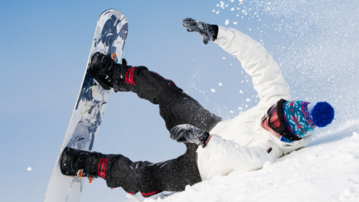 Person på snowboard som har falt i en skibakke.