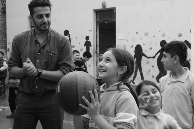 Black and white photo of school children playing basket ball