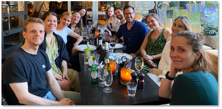 The members of the research group gathered around a restaurant dining table.