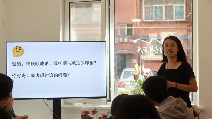 Woman smiling in front of a screen. 