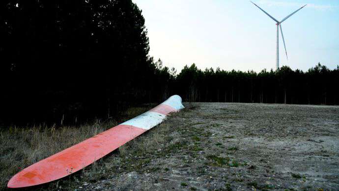 Wind turbine rotor blade and wind turbine in the background.