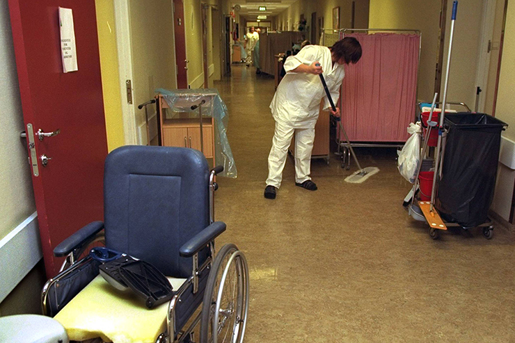 Ullevål sykehus. En rullestol i forgrunnen. Rengjøring av en korridor. 