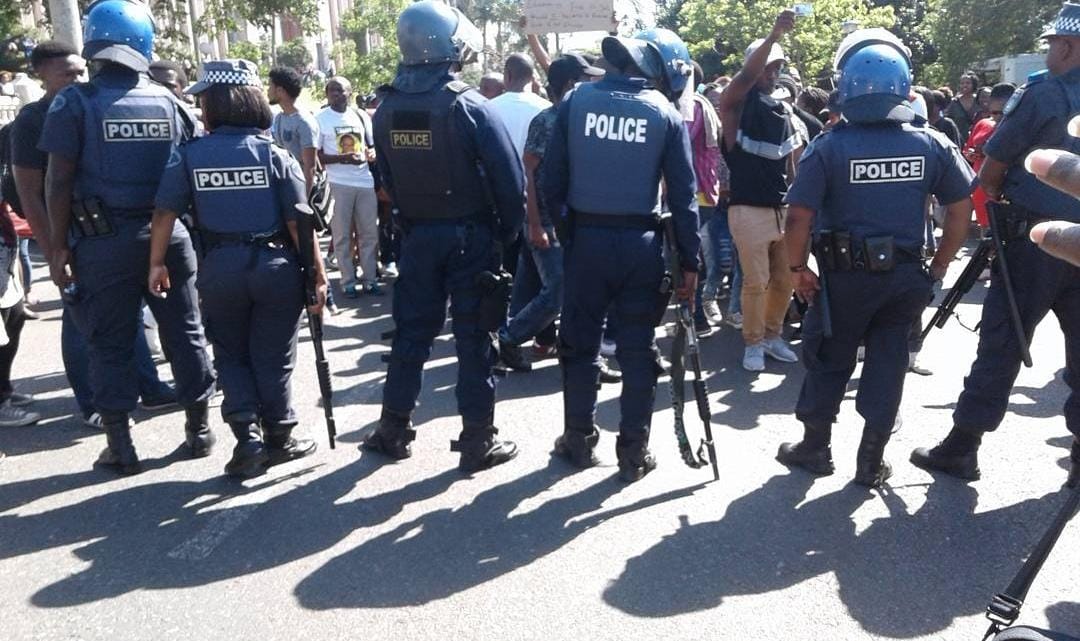 Police with guns in front of protesting students