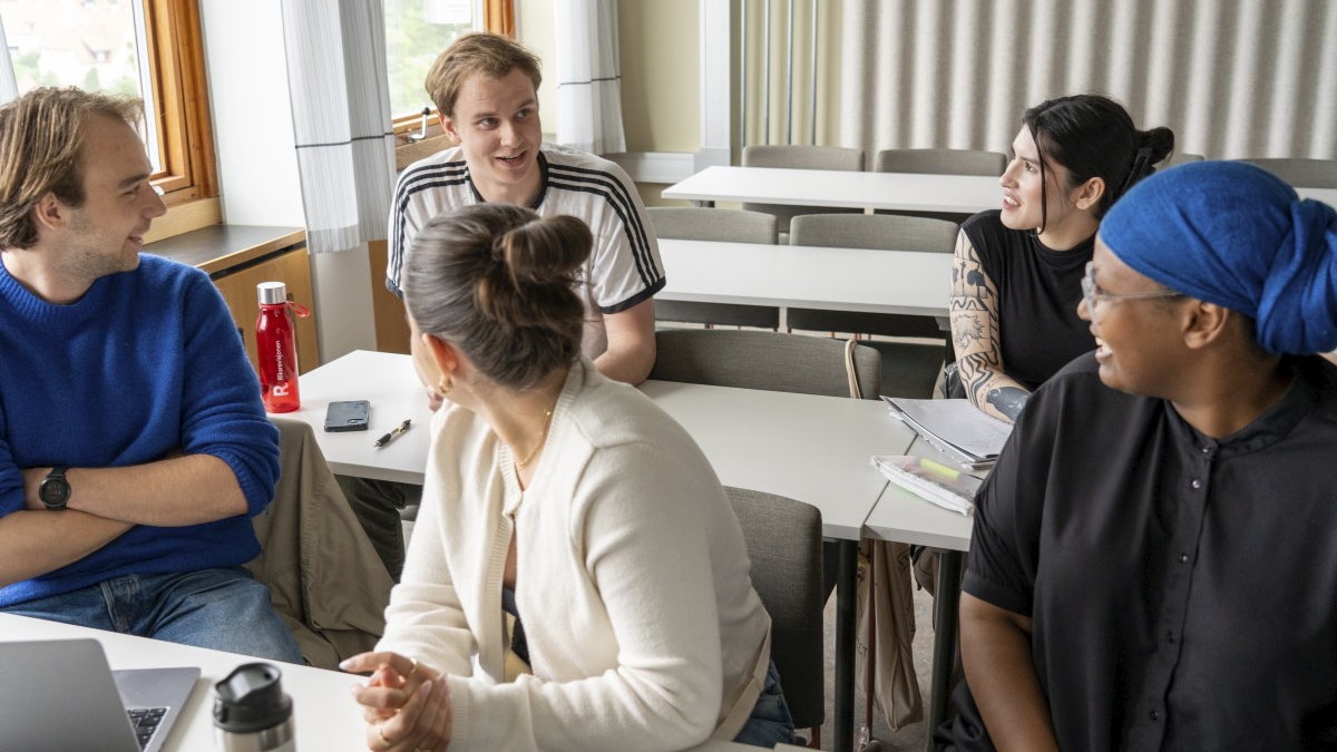 Five students sitting together in a classroom