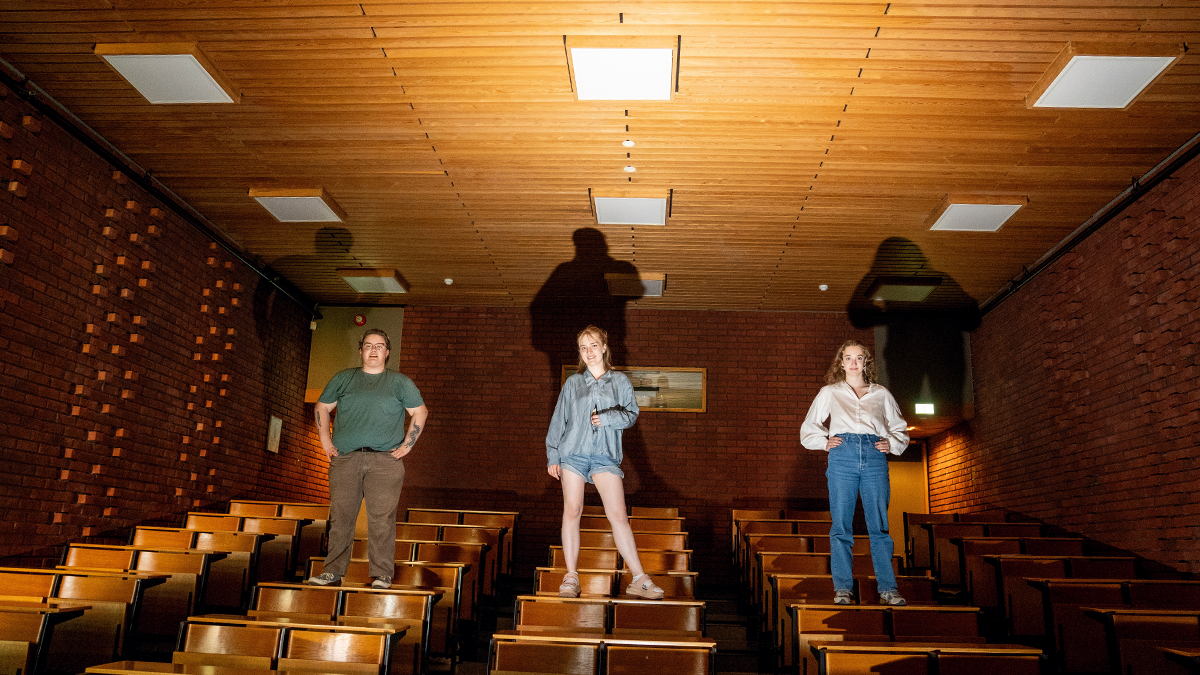 Three students on the table in auditorium